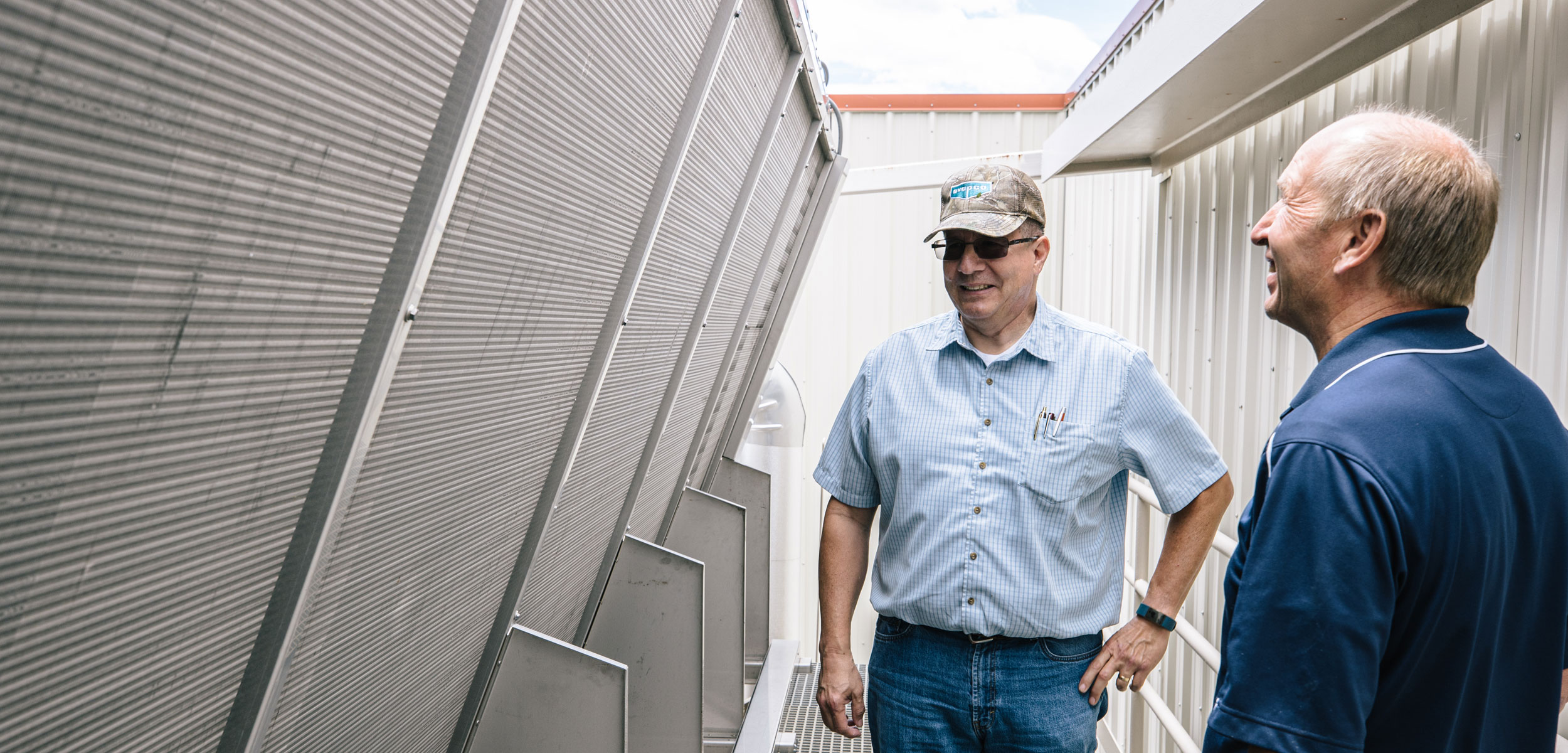 Midgley-Huber Engineer and USU Facilities Manager stand beside EVAPCO dry cooler.